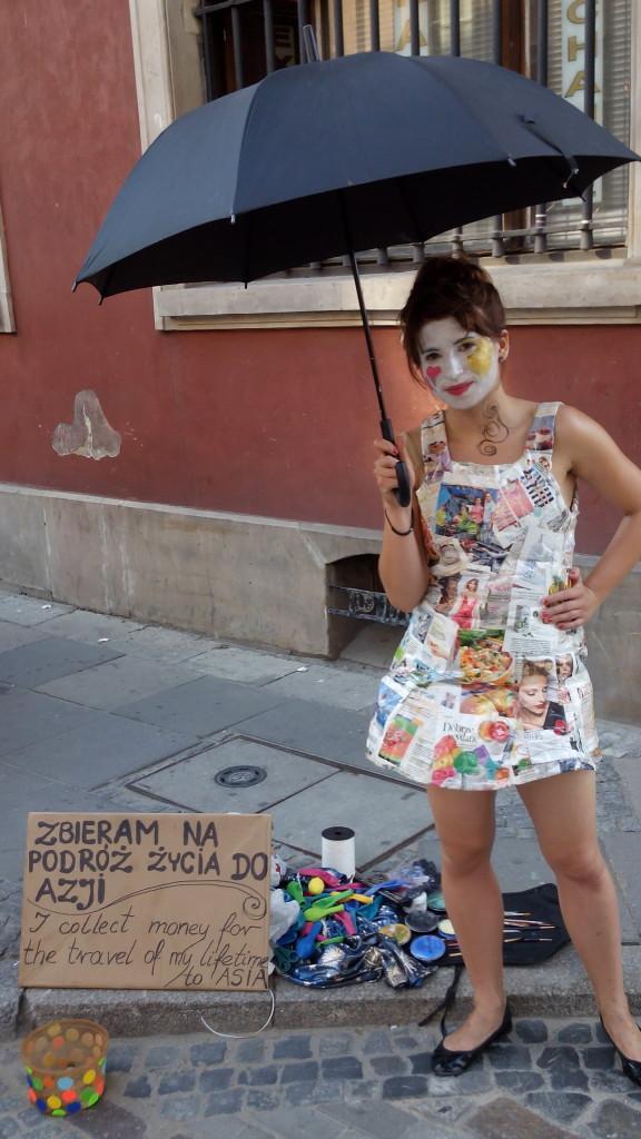 Эту девушку я встретил в центре Варшавы, она в платье из газет. Вы можете фоткаться с ней, получить шарик и помочь ей путешествовать. На ёё табличке написано: «Собираю деньги на путешествие всей моей жизни в Азию»